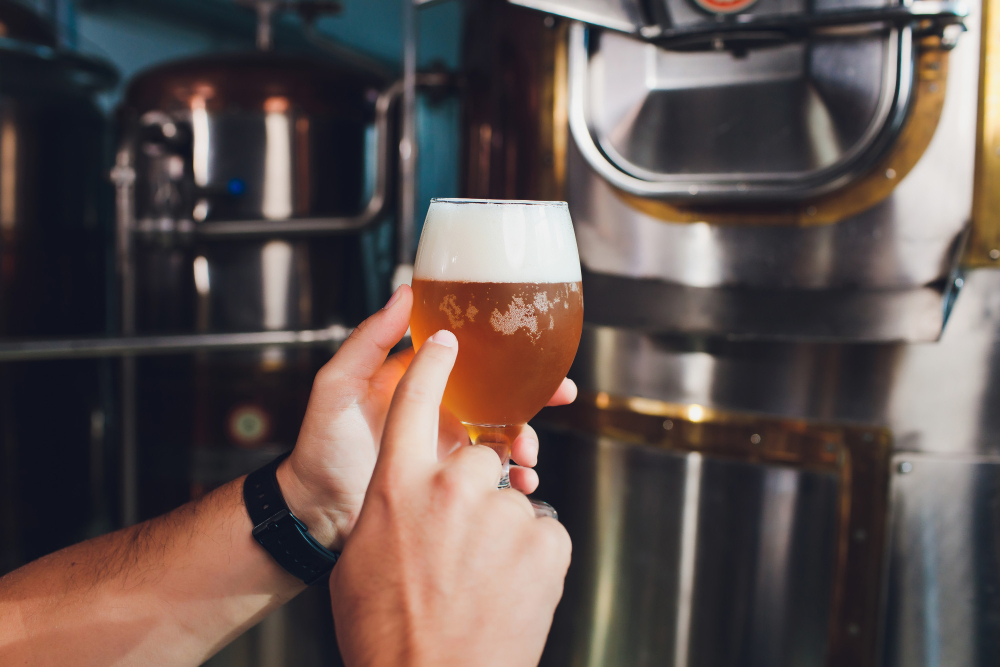 Brewer holds glass with craft beer